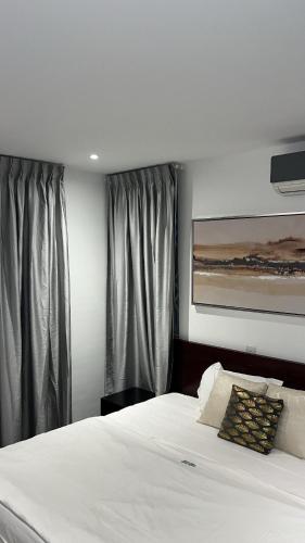 库马西Nuben Court- Kumasi City的卧室配有白色大床和窗帘