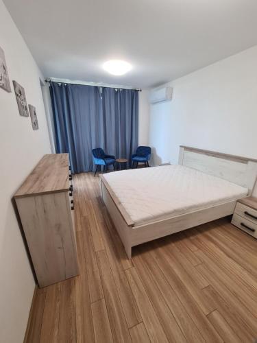 瓦尔纳Sky flats Varna with parking的一间卧室配有一张床和两张蓝色椅子