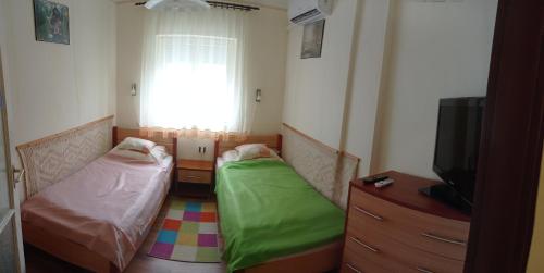 包道乔尼托毛伊Kámán Nyaraló的客房设有两张床、一台电视和一扇窗户。