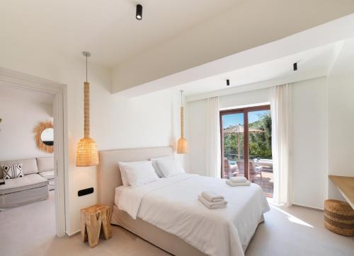 SpanokhórionAnemones Villas by Omikron Selections的一间白色卧室,配有床和庭院