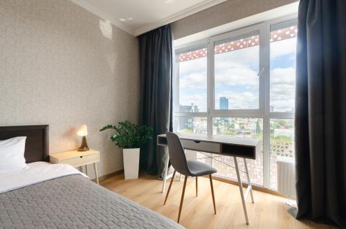 基辅0727 Kvartet cozy apartment nearby with Central Railway Station的一间卧室配有书桌、床和窗户。