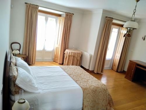 阿托吉亚达巴莱亚CASA DO LARGO的一间卧室设有一张大床和两个窗户。