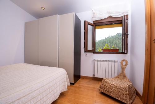利亚内斯Cerezal 3, Loft en plena naturaleza的一间卧室设有一张床、一个窗口和一把椅子