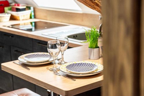 博讷SOUS LE HAUT DES REMPARTS的厨房里一张桌子,上面有两杯和盘子