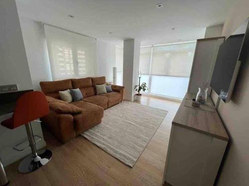 希洪Precioso apartamento recién reformado的客厅配有棕色沙发和电视