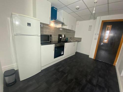巴尔内特Barnet 1 Spacious 2-Bed Apartment的厨房配有白色冰箱和黑色地板