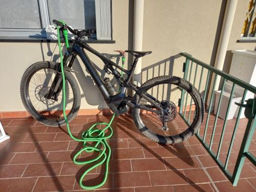 菲纳莱利古雷NIDO TRA GLI ULIVI的一辆自行车,上面有绿水管,挂在铁轨上