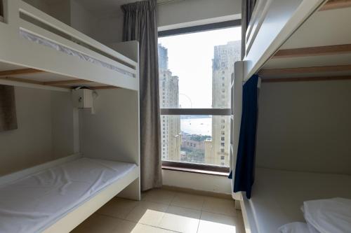 迪拜Travel Hub Premium的客房设有两张双层床和一扇窗户。