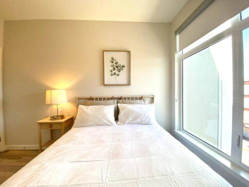 悉尼Lovely Brand New Condo的卧室配有一张大白色床和窗户