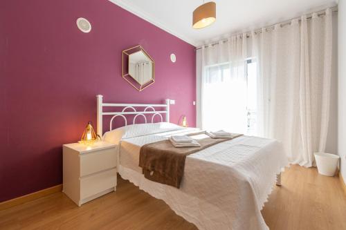 楼尔Apartamento Mãe Soberana的卧室配有白色的床和紫色墙壁