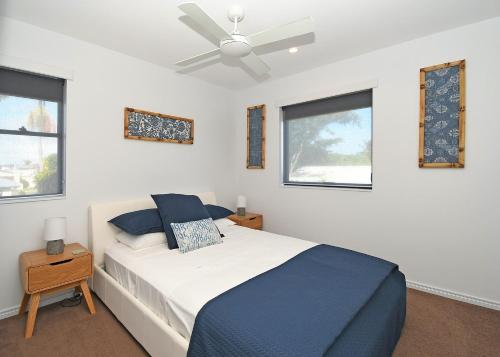 赫维湾Luxurious Beachfront Apartment的一间卧室配有一张床和吊扇