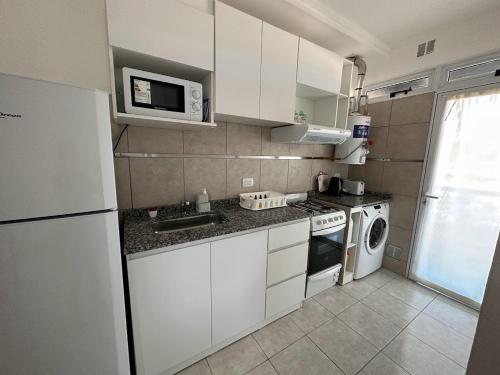 埃斯佩兰萨DON SIMON Apart 8 -departamento nuevo的小厨房配有白色橱柜和微波炉