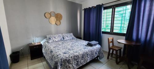 圣克鲁斯Hostal Backpackers Travelero的一间卧室配有一张床、一张桌子和一个窗户。