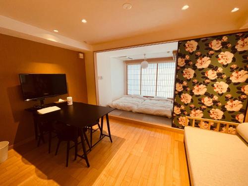 东京Nplus Tokyo Akihabara Premium的一间带桌子的客厅和一间卧室