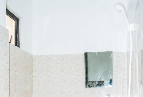 宿务Magabelle Guesthouse的一间带镜子和淋浴的浴室