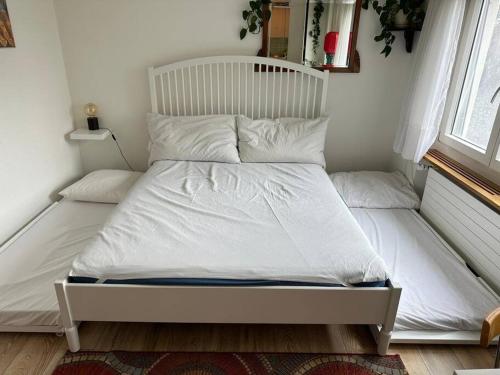 奥斯特蒙迪根Pipin’s Studio的卧室内的一张带白色床单和枕头的床