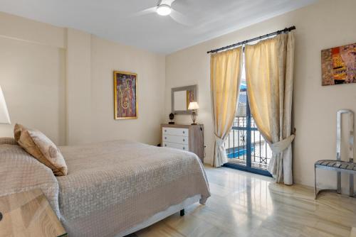 马贝拉Beachfront Puerto Banus的一间卧室设有一张床和一个阳台的窗户。