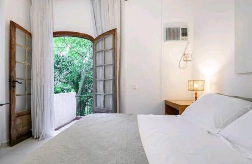 里约热内卢Santa Teresa Junto à Natureza的一间卧室设有一张床和一个大窗户