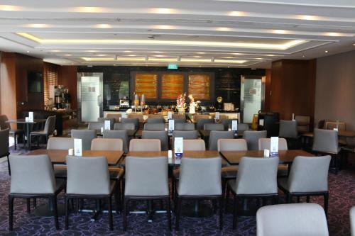 新加坡Aqueen Hotel Paya Lebar的一间会议室,里面配有桌椅