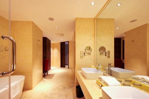 深圳深圳湾科技园丽雅查尔顿酒店的浴室设有2个水槽、浴缸和镜子