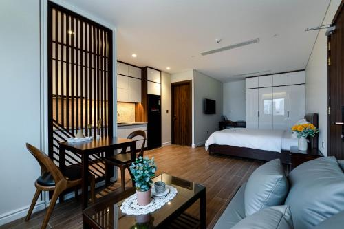 岘港MK Riverside Apartment by Haviland的客厅和卧室(带一张床和一张桌子)