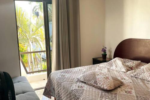 坎昆Cómoda casa céntrica con alberca privada en Cancún的一间卧室设有一张床和一个滑动玻璃门