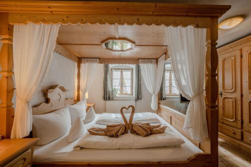 米滕瓦尔德费恩豪斯比奇勒酒店的卧室配有带白色窗帘的天蓬床