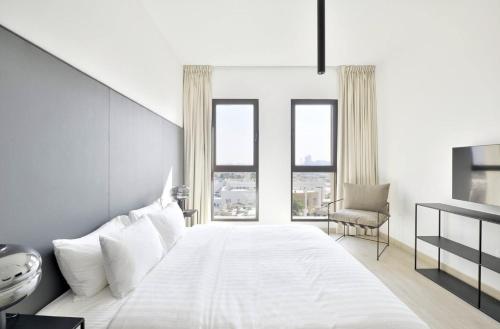 迪拜Madinat Jumeirah Living, MJL Dubai的卧室设有一张带窗户的白色大床