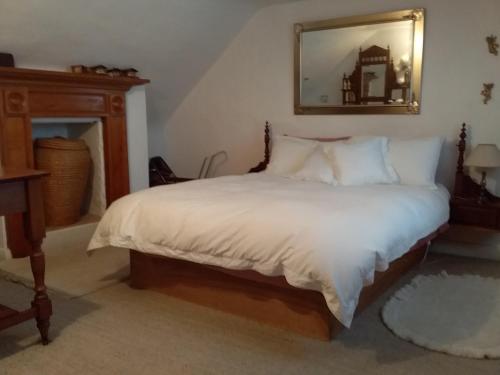 霍巴特Josie's Cottage的一间卧室配有一张带白色床单和镜子的床