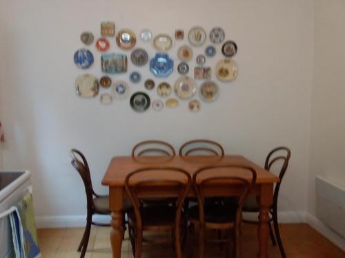 霍巴特Josie's Cottage的餐桌、椅子和盘子挂在墙上