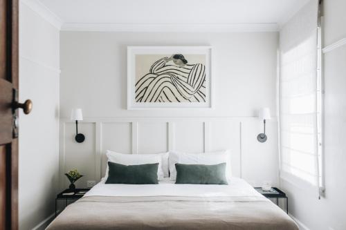 莫斯谷道儿米房屋酒店的卧室配有一张床,墙上挂有绘画作品