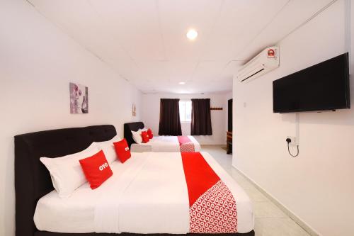 马六甲OYO 1132 Azimaju Guesthouse的卧室配有带红色枕头的大型白色床
