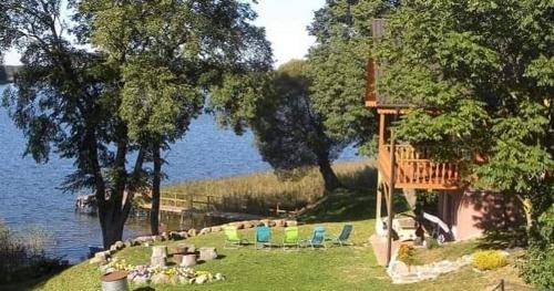 InturkėŠAMO UOSTAS - vila šeimoms ant ežero kranto的一群椅子坐在水边的草上