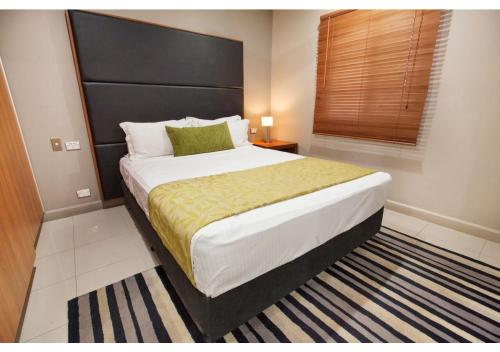 莫尔兹比港埃拉海滩酒店的一间卧室配有一张大床和黑色床头板