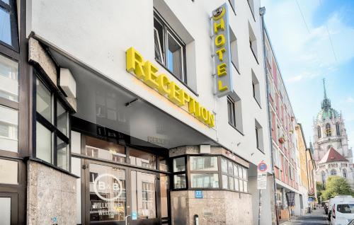 慕尼黑B&B Hotel München-Hbf的建筑的侧面有黄色标志