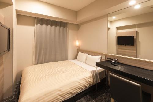 东京相铁夫里萨新桥西必亚酒店的酒店客房,配有床和镜子
