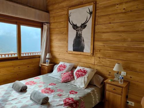 瓦尔代布洛尔Chambres d'hôtes Le Grand Chalet的卧室配有一张挂着鹿图的床铺。