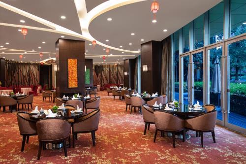 青浦上海夏阳湖皇冠假日酒店 的用餐室设有桌椅和窗户。