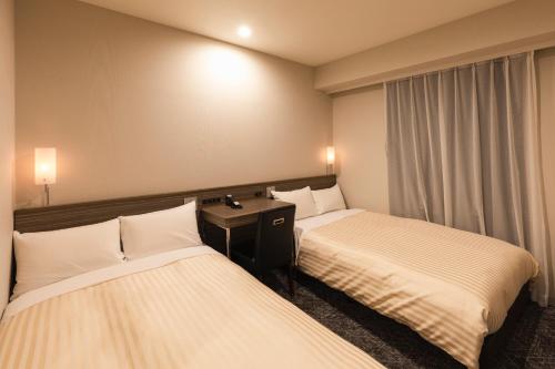 东京相铁夫里萨新桥西必亚酒店的酒店客房设有两张床和窗户。