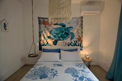马尔扎梅米Villa Colapesce的卧室配有一张挂在墙上的乌龟挂毯床。