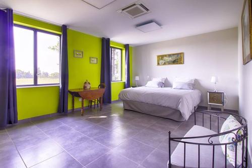 奥朗日La maison des Eucalyptus - Piscine, jacuzzis et lac的一间卧室设有绿色的墙壁、一张床和一张书桌