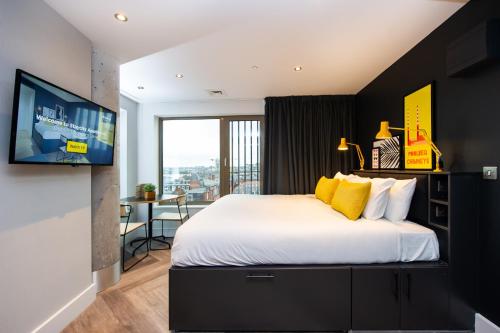 都柏林Staycity Aparthotels Dublin Castle的卧室配有一张带黄色枕头的大型白色床。