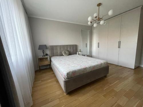维尔纽斯SAULETEKIO APARTMENT的一间卧室配有一张床和一个吊灯