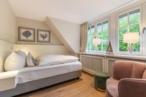 凯图姆Inselliebe Exklusive Sylter Wellnessoase mit Sauna Garten in Keitum的一间卧室设有一张床和两个窗户。