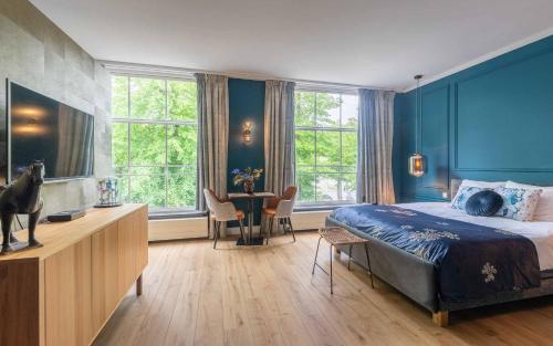 奥斯特豪特Heuvelsuites的一间拥有蓝色墙壁的卧室,配有一张床和一张桌子