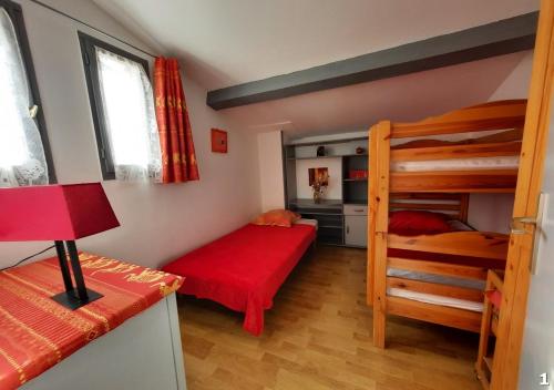 韦尔东的埃斯帕隆Appartements Hameau du Port的一间卧室配有两张双层床和一张红色的床。