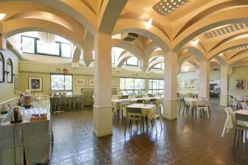 马里纳－迪拉文纳Hotel Maddalena的一间带桌椅和天花板的用餐室