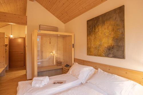 皮耶韦迪卡多雷Giallo Dolomiti Wellness的卧室配有白色的床和墙上的绘画作品
