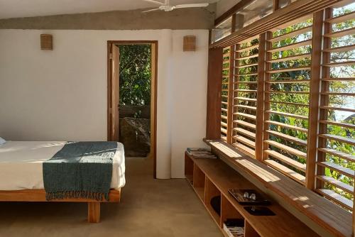 帕拉蒂REFUGIO na frente do mar em Ilha de Araujo的一间卧室设有一张床和一个大窗户