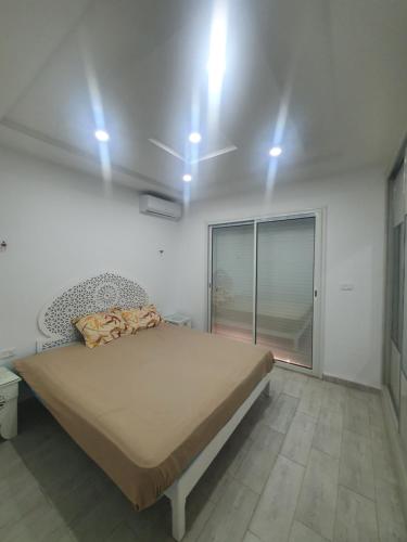 阿格希尔Villa de luxe avec piscine sans vis à vis Midoun的一间卧室配有一张天花板上灯床。